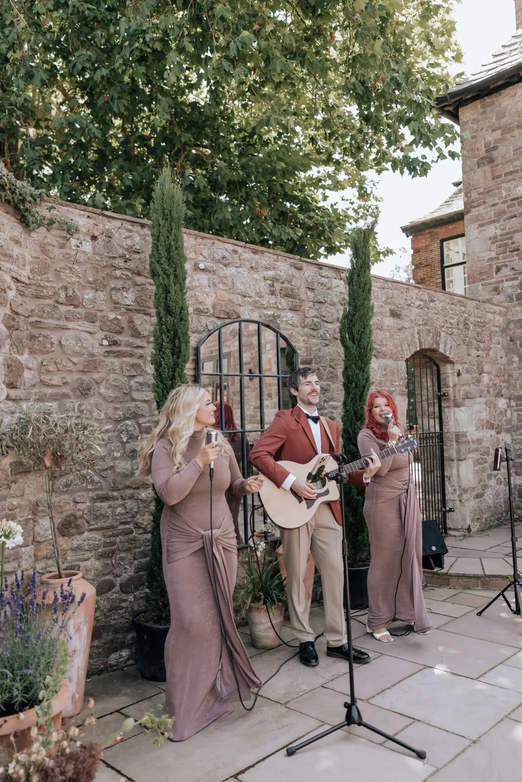 Live singers and guitarist performing in a stone courtyard